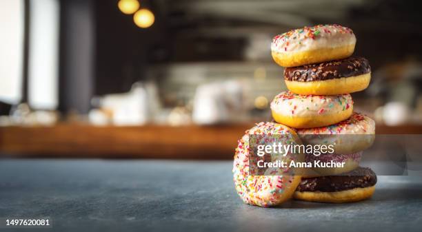 different multicolored sweet donuts donuts with icing and sprinkles with copy space - doughnut stock pictures, royalty-free photos & images