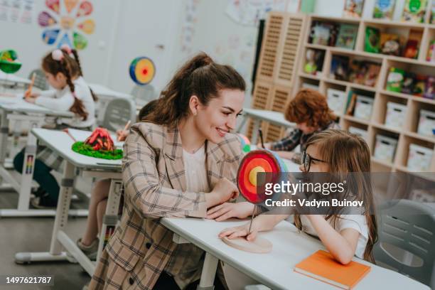 schoolgirl and female teacher discussing  cross-section of planet earth diy model in classroom - geology student stock pictures, royalty-free photos & images