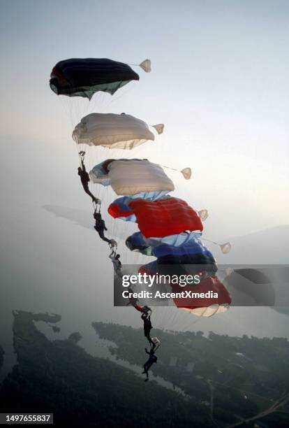 skydive athletes perform above swiss mountain landscape - height stock pictures, royalty-free photos & images