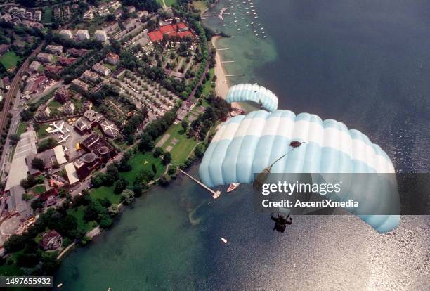 skydive athletes perform above swiss mountain landscape - paraquedas imagens e fotografias de stock