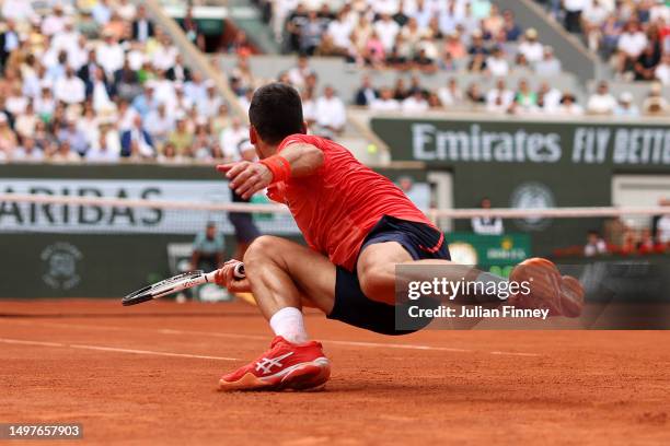 Novak Djokovic of Serbia slips against Casper Ruud of Norway during the Men's Singles Final match on Day Fifteen of the 2023 French Open at Roland...