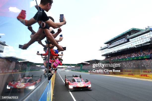 The No.51 Ferrari AF Corse Ferrari 499P of Alessandro Pier Guidi, James Calado and Antonio Giovinazzi passes celebrating team after winning the 100th...