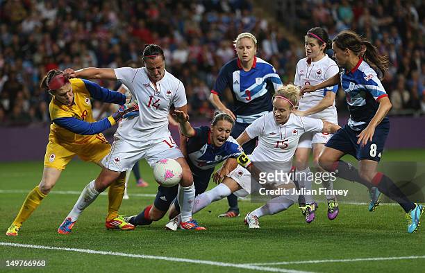 Casey Stoney of Great Britain goes down in the penalty box with pressure from Melissa Tancredi of Canada and Kelly Parker of Canada during the...