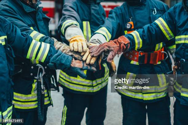 vigili del fuoco con le mani accatastate - firefighter foto e immagini stock