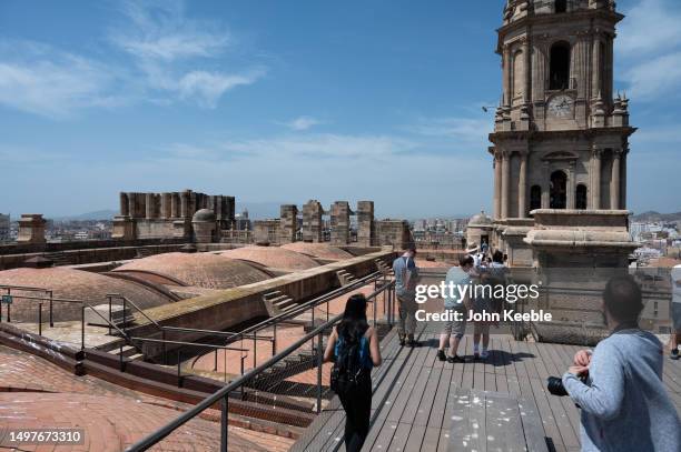 Tourists view the unfinished and completed towers on the roof of the Malaga Cathedral on April 21, 2023 in Malaga, Spain.