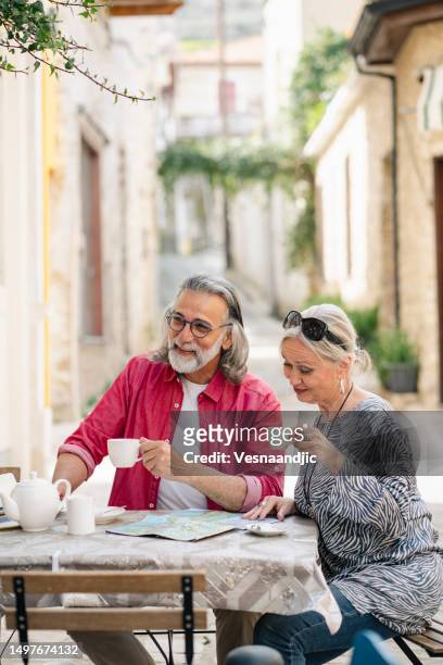 reifes paar als tourist, genießt lokalen kaffee im café in der seitenstraße, zypern - limassol stock-fotos und bilder