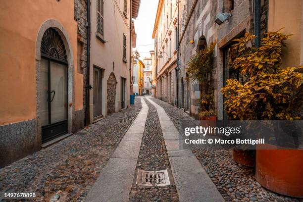 narrow alley in the old town of como, italy - province de côme italie photos et images de collection