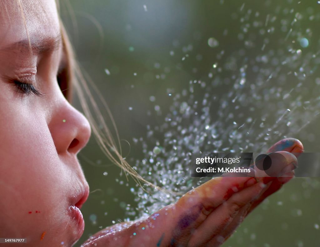 Child blowing glitter