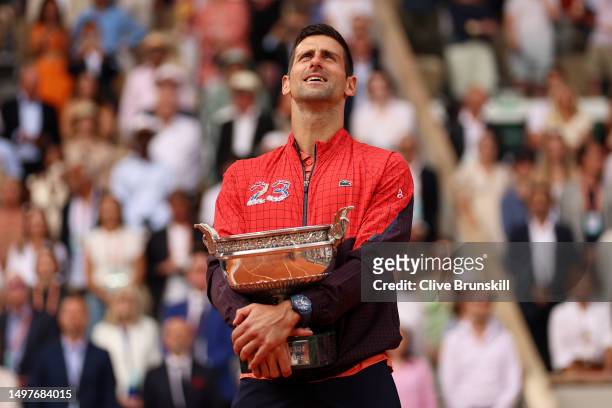 Novak Djokovic of Serbia holds the winners trophy during the national anthem after victory against Casper Ruud of Norway in the Men's Singles Final...