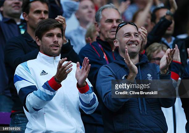 Daniel Vallverdu, hitting partner to Andy Murray of Great Britain, and fitness coach Jez Green cheer for Murray against Novak Djokovic of Serbia in...
