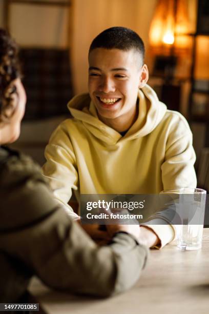 caring mother gently caressing teenage son's face and giving heartfelt advice - oost europese etniciteit stockfoto's en -beelden