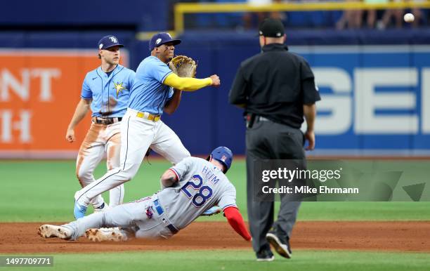 Wander Franco of the Tampa Bay Rays turns a double play to end the game as Jonah Heim of the Texas Rangers slides into second during a game at...