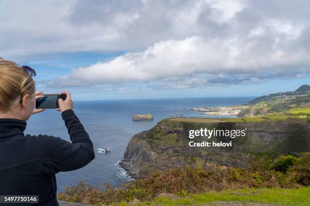 women photographing coastline near mosteiros on sao miguel, azores - ponta delgada stock pictures, royalty-free photos & images