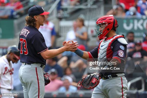 Hunter Harvey and Keibert Ruiz of the Washington Nationals celebrate their 6-2 win over the Atlanta Braves at Truist Park on June 11, 2023 in...