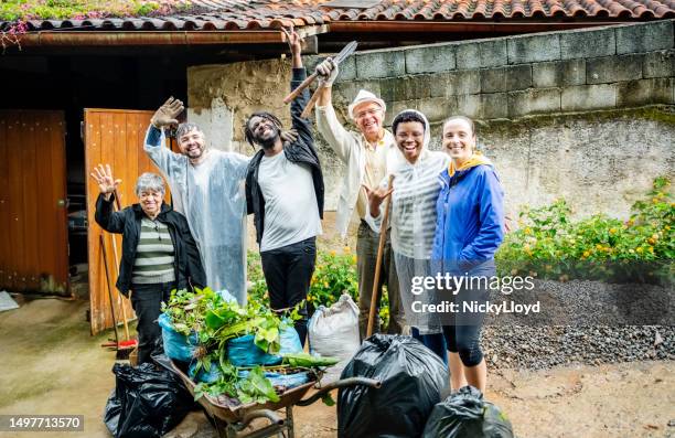 gruppe verschiedener freiwilliger, die zusammenstehen und am tag der gemeinschaftsreinigung jubeln - reinigungsfahrzeug stock-fotos und bilder