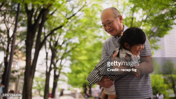 grandfather playing with her granddaughter in public park - human limb 個照片及圖片檔