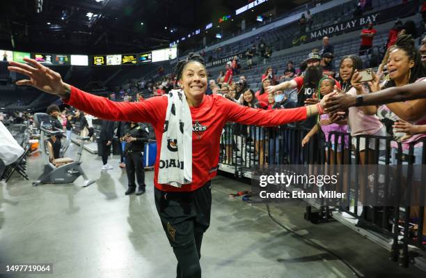 Candace Parker of the Las Vegas Aces reaches out to fans as she runs off the court after the team's 93-80 victory over the Chicago Sky at Michelob...