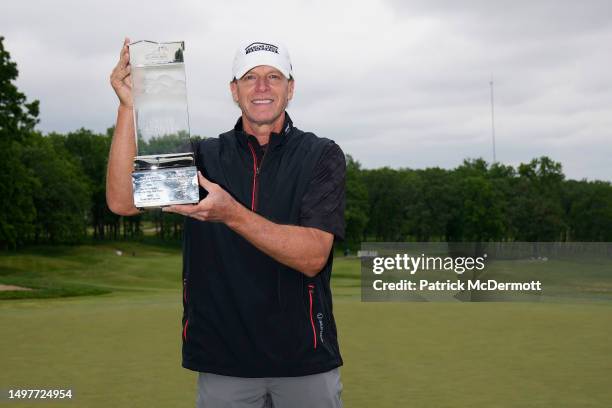 Steve Stricker of United States holds the winner's trophy on the 18th green after winning the American Family Insurance Championship at University...