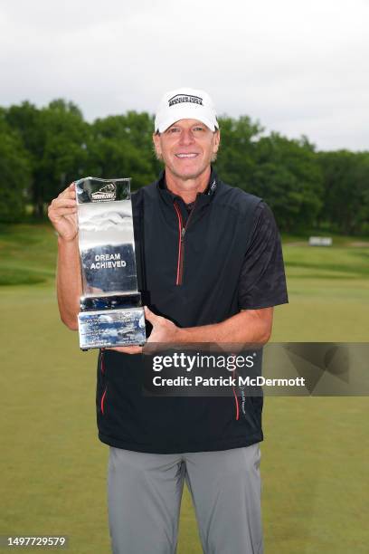 Steve Stricker of United States holds the winner's trophy on the 18th green after winning the American Family Insurance Championship at University...