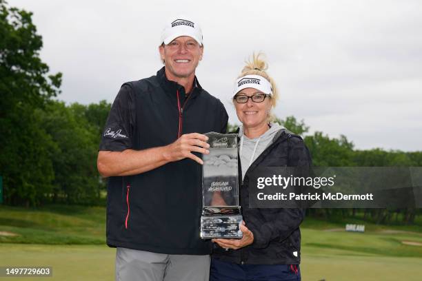 Steve Stricker of United States holds the winner's trophy with his caddie and wife Nicki Stricker on the 18th green after winning the American Family...