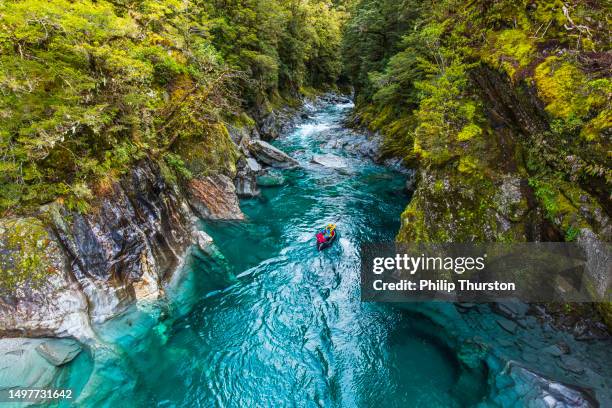 kayaking down river rapids in the mountains of new zealand - kayaking rapids stock pictures, royalty-free photos & images