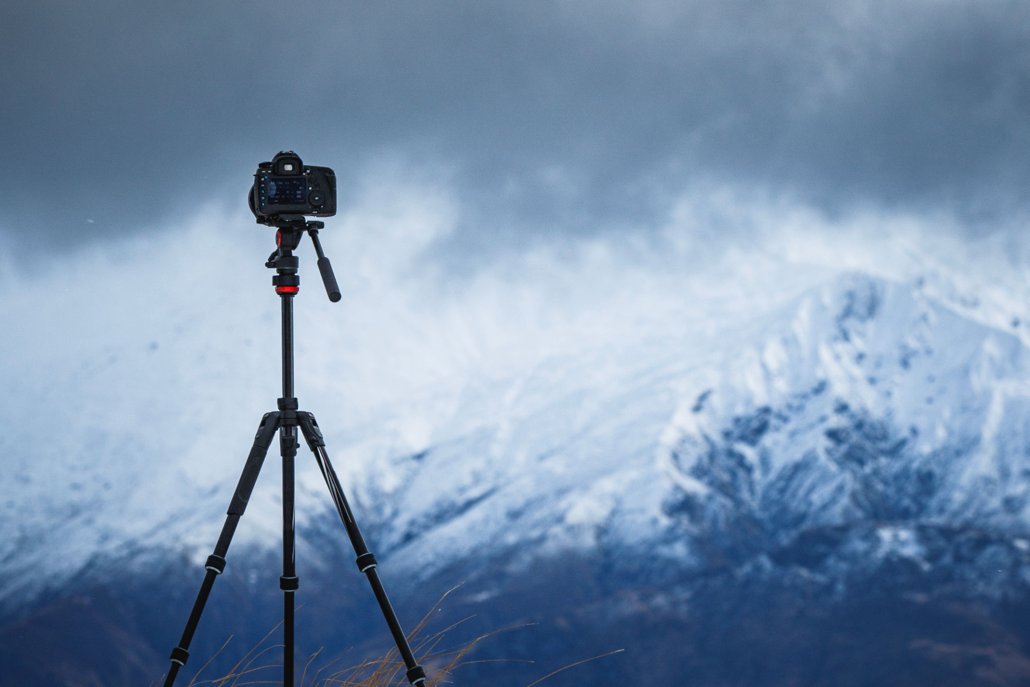 Equipamento de câmera na configuração do tripé tirando fotografias da paisagem dramática da montanha Equipamento de câmera na configuração do tripé tirando fotografias da paisagem dramática da montanha