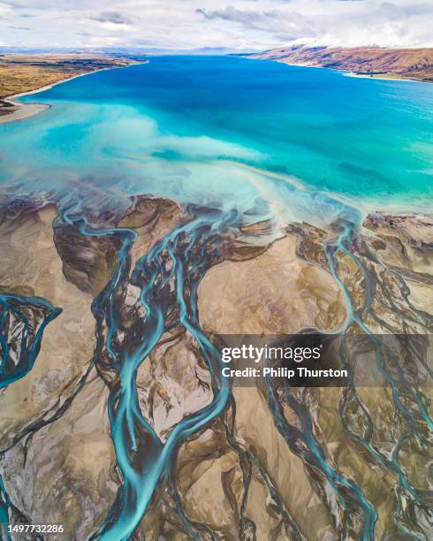 aerial perspective of river braid system from glacial runoff with scenic turquoise lake and snow covered mountains - verdigris river bildbanksfoton och bilder