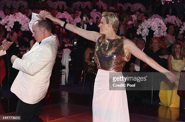 Prince Albert II of Monaco and Princess Charlene of Monaco dance during the 64th Red Cross Ball Gala in Salle des Etoiles at Sporting Monte-Carlo on...