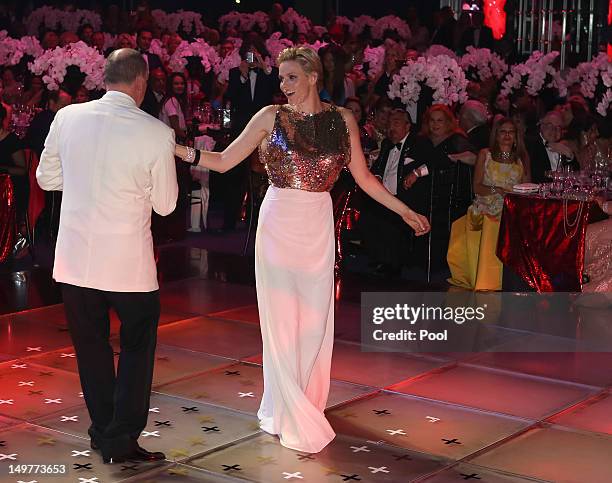 Prince Albert II of Monaco and Princess Charlene of Monaco dance during the 64th Red Cross Ball Gala in Salle des Etoiles at Sporting Monte-Carlo on...