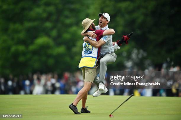 Nick Taylor of Canada celebrates with his caddie after making an eagle putt on the 4th playoff hole to win the RBC Canadian Open at Oakdale Golf &...
