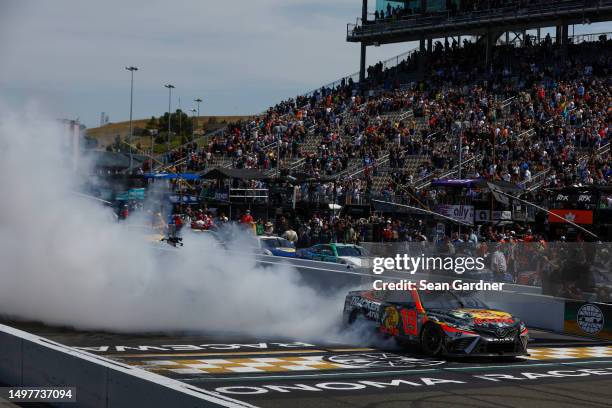 Martin Truex Jr., driver of the Bass Pro Shops Toyota, celebrates with a burnout after winning the NASCAR Cup Series Toyota / Save Mart 350 at Sonoma...