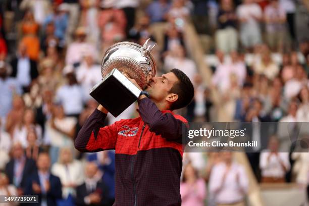 Novak Djokovic of Serbia kisses the winners trophy after victory against Casper Ruud of Norway in the Men's Singles Final match on Day Fifteen of the...