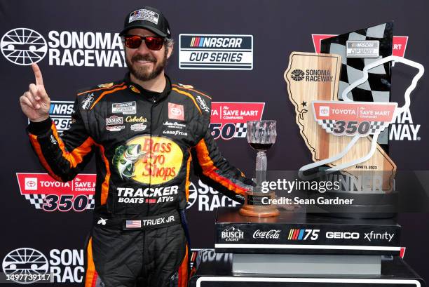 Martin Truex Jr., driver of the Bass Pro Shops Toyota, celebrates in victory lane after winning the NASCAR Cup Series Toyota / Save Mart 350 at...