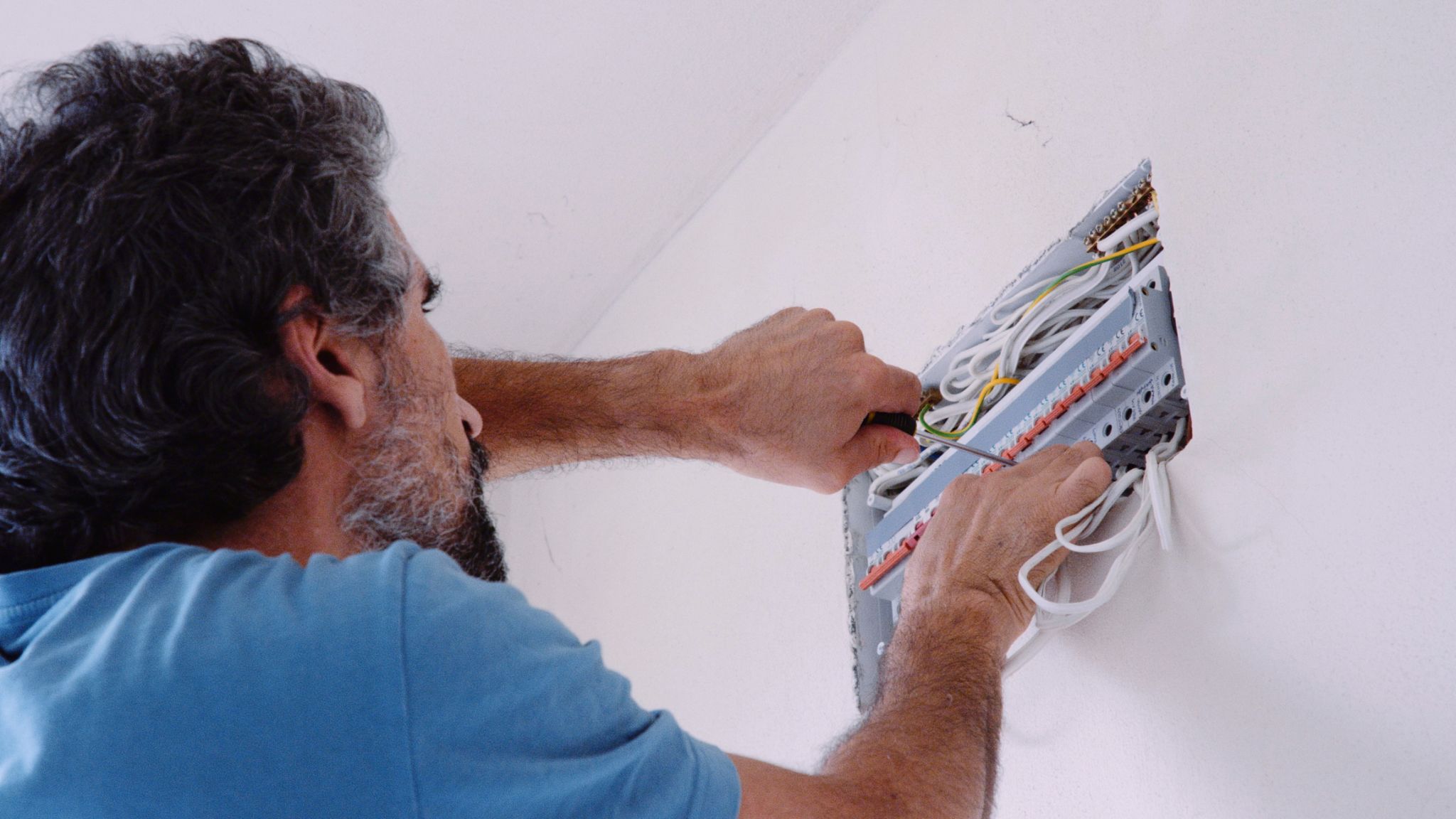 Man works on mains fuse box in a new home. DIY. Man works on mains fuse box in a new home. DIY.