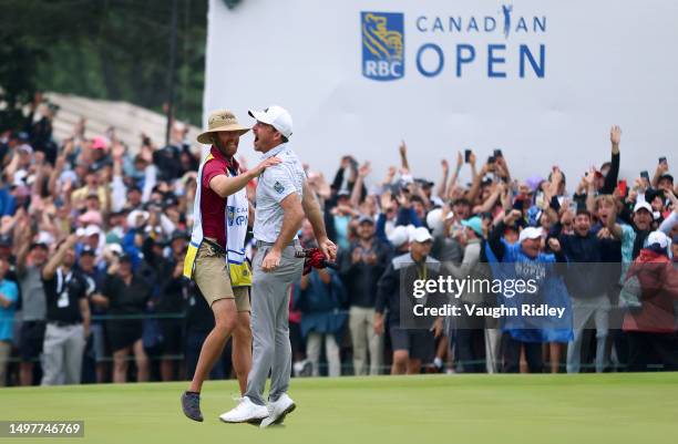 Nick Taylor of Canada celebrates with his caddie after making an eagle putt on the 4th playoff hole to win the RBC Canadian Open at Oakdale Golf &...