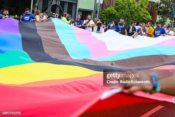 Attendees hold large Pride flag at the 2023 LA Pride Parade on June 11, 2023 in Hollywood, California.