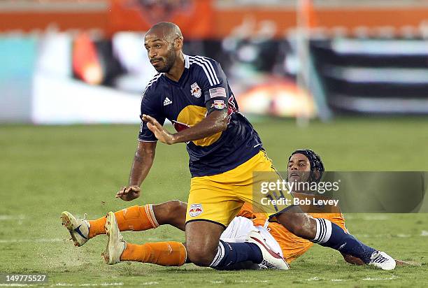Thierry Henry of the New York Red Bulls is taken down from behind by Calen Carr of the Houston Dynamo in the first half at BBVA Compass Stadium on...