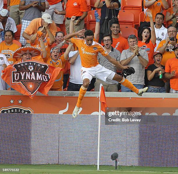 Calen Carr of the Houston Dynamo leaps over the corner flag after scoring against the New York Red Bulls in the first half at BBVA Compass Stadium on...