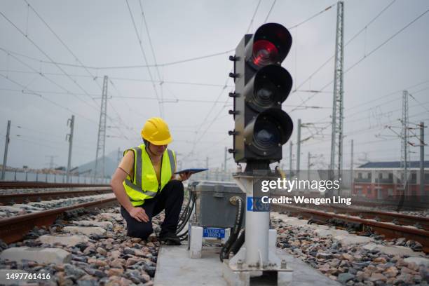 arbeiter, der eisenbahnsignalleuchten überprüft - bahnübergangsschild stock-fotos und bilder
