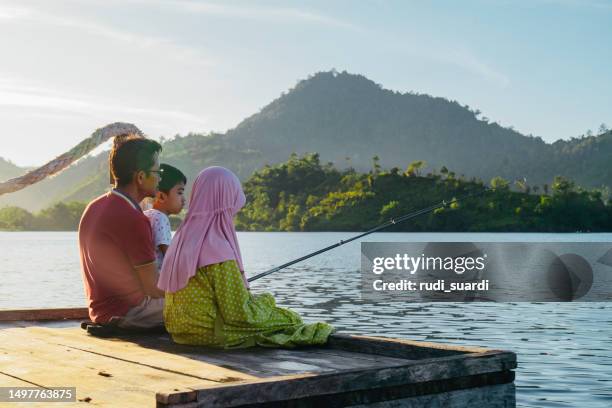 shot of a father and son and daughter fishing together - anständig klädsel bildbanksfoton och bilder
