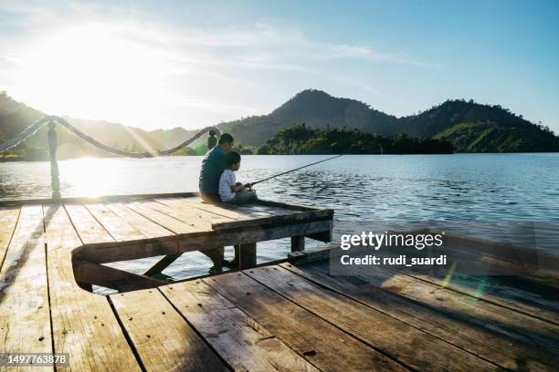 shot of a father and son fishing together - rod stock pictures, royalty-free photos & images