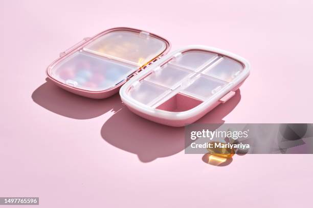 pink pill box with pills and vitamins on a pink background. - pill organizer stock pictures, royalty-free photos & images