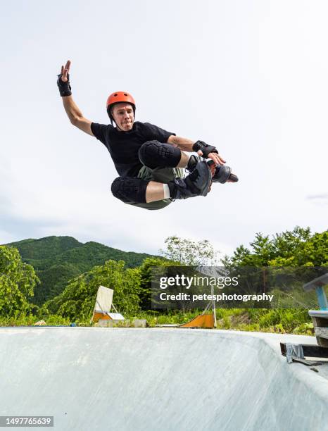 a middle age man getting air inline skating at a skate park - iwate prefecture stock pictures, royalty-free photos & images