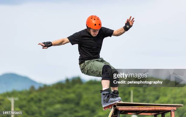 a man performing a "grind" inline skating at a skate park - iwate prefecture stock pictures, royalty-free photos & images