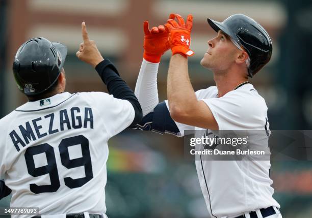 Kerry Carpenter of the Detroit Tigers celebrates with first base coach Alfredo Amezaga after hitting a single against the Arizona Diamondbacks during...