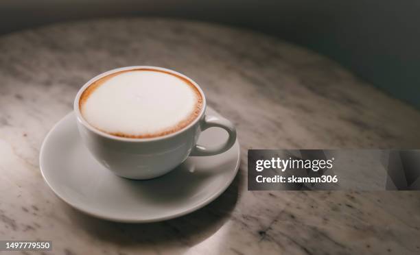 close up cappuccino cup with lighting and copy space darken background - coffee table cafe stock pictures, royalty-free photos & images