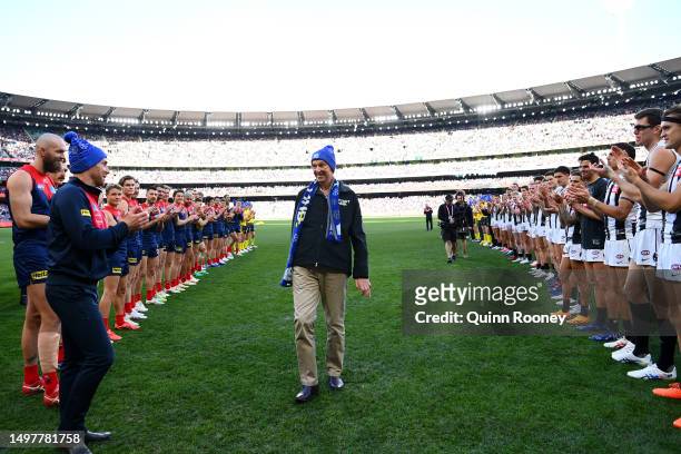 Neale Daniher walks through a guard of honour from Demons and Magpies players ahead of the round 13 AFL match between Melbourne Demons and...