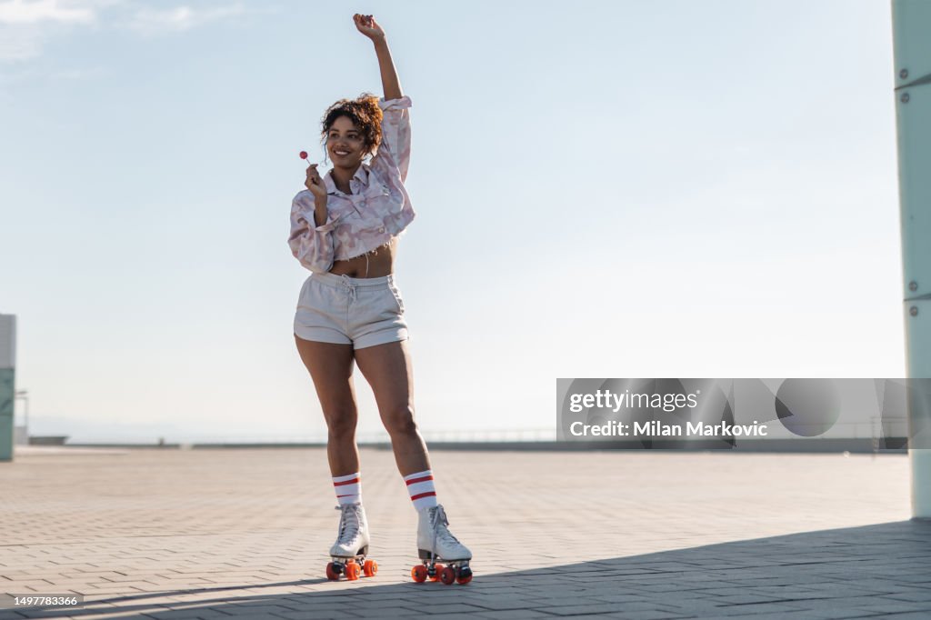 Young Spanish woman rollerblading on the promenade by the sea.