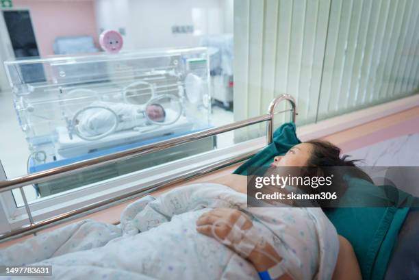 on the first day of the first meet, an asian mother was overjoyed to see his newborn son in an incubator. - prematuro imagens e fotografias de stock