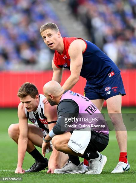 Lachie Hunter of the Demons checks on Will Hoskin-Elliott of the Magpies after bumping into each other during the round 13 AFL match between...